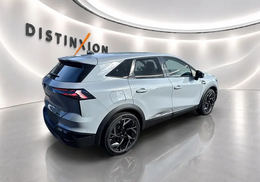 Renault Symbioz gris rafale en vue 3/4 arrière droit, avec jantes noires et toit noir contrasté dans un showroom lumineux.