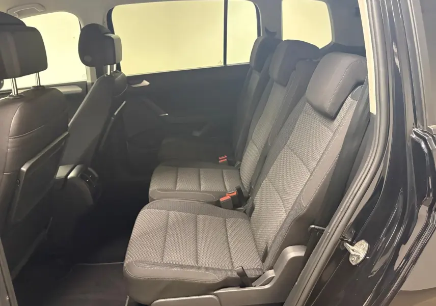 Vue intérieure côté droit sur la banquette arrière en tissu gris du Volkswagen Touran Noir Intense 2024.