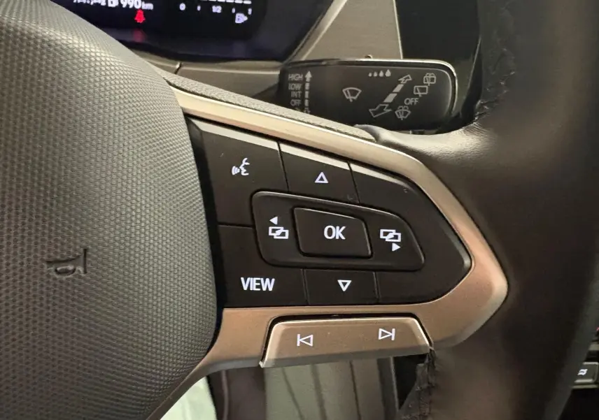 Gros plan sur les commandes multifonctions à droite du volant du Volkswagen Touran 2024 noir intense nacré.