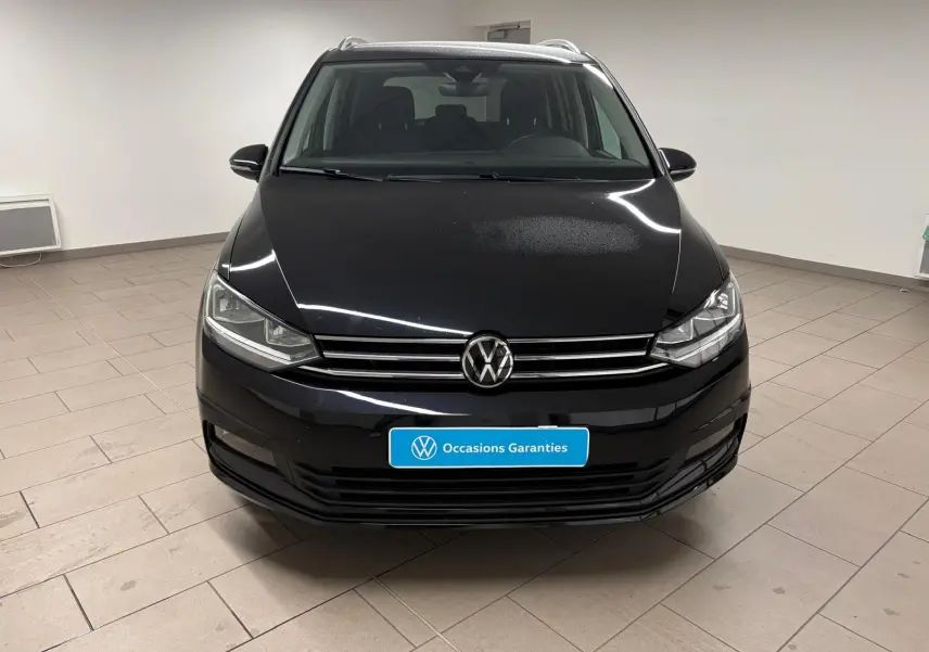 Volkswagen Touran noir intense nacré vu de face, mettant en valeur la calandre et les phares LED.