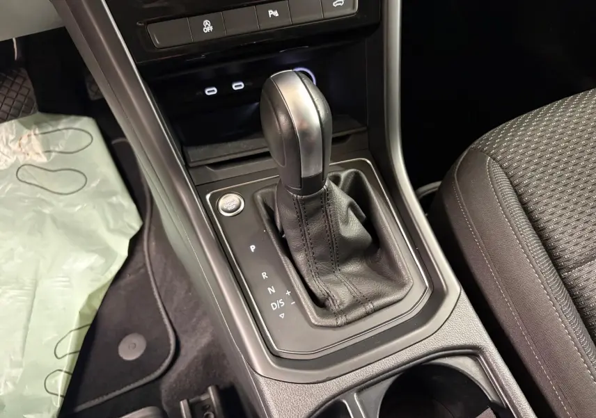Gros plan sur la console centrale du Volkswagen Touran 2024 avec levier de vitesse automatique et bouton start/stop.
