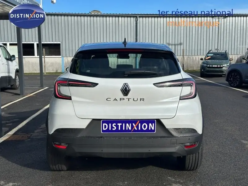 Vue arrière d'un Renault Captur blanc nacré avec toit noir étoile, feux arrière LED et plaque Distinxion.