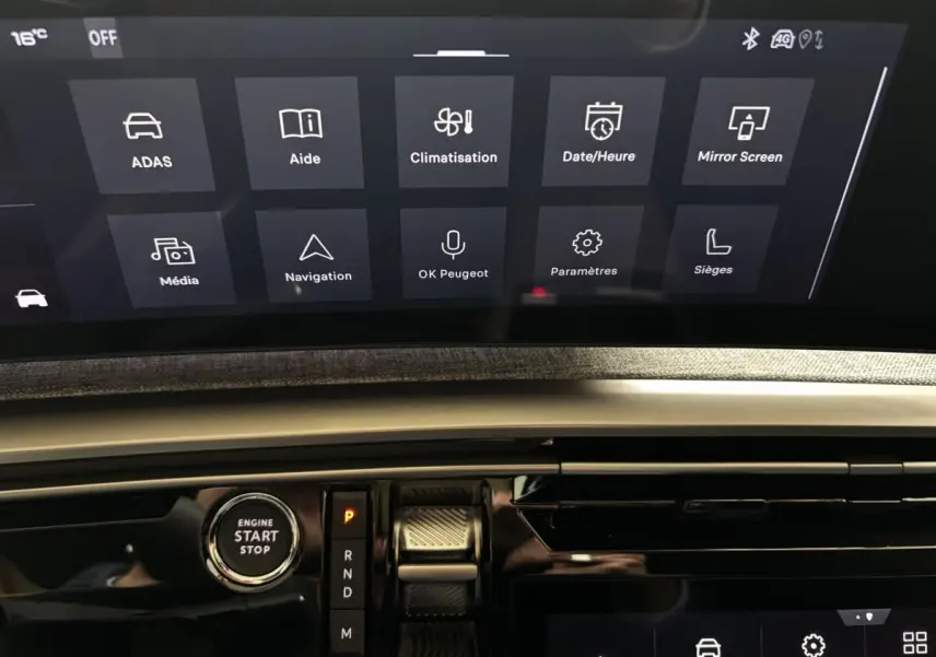 Vue rapprochée de l’écran tactile central et du bouton start/stop du tableau de bord du Peugeot 3008 vert 2025.