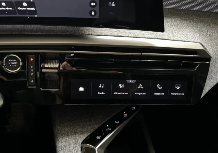 Vue rapprochée de la console centrale noire brillante du Peugeot 3008 1.2 Hybrid 145 GT avec écran tactile et bouton start/stop.