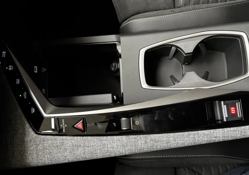 Détail de la console centrale grise avec commandes tactiles et porte-gobelets du Peugeot 3008 hybride 2025.