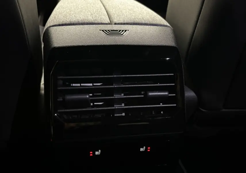 Vue rapprochée de la ventilation arrière et des commandes de sièges chauffants du Peugeot 3008 vert, intérieur sombre.