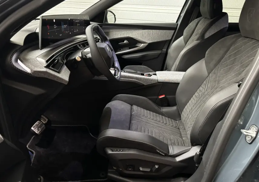 Vue intérieure côté conducteur du Peugeot 3008 1.2 Hybrid 145 GT 2025, sièges cuir et alcantara gris, écran tactile large.