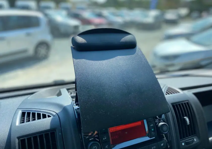 Vue rapprochée de la console centrale du Citroën Jumper 2023, écran radio rouge avec cache rabattable noir.