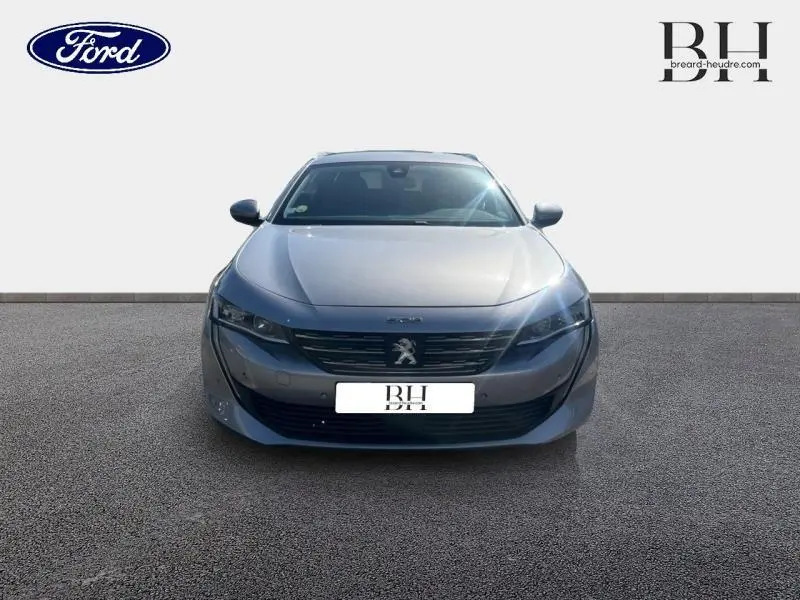 Peugeot 508 SW gris Artense vue de face, mettant en valeur sa calandre chromée et ses phares LED fins.