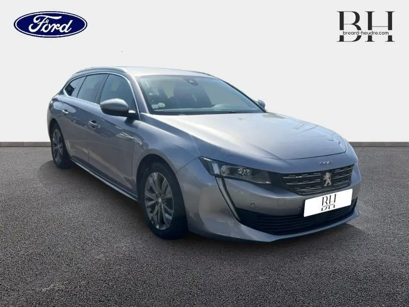 Peugeot 508 SW gris Artense en vue 3/4 avant droit, avec calandre chromée et jantes alu visibles.
