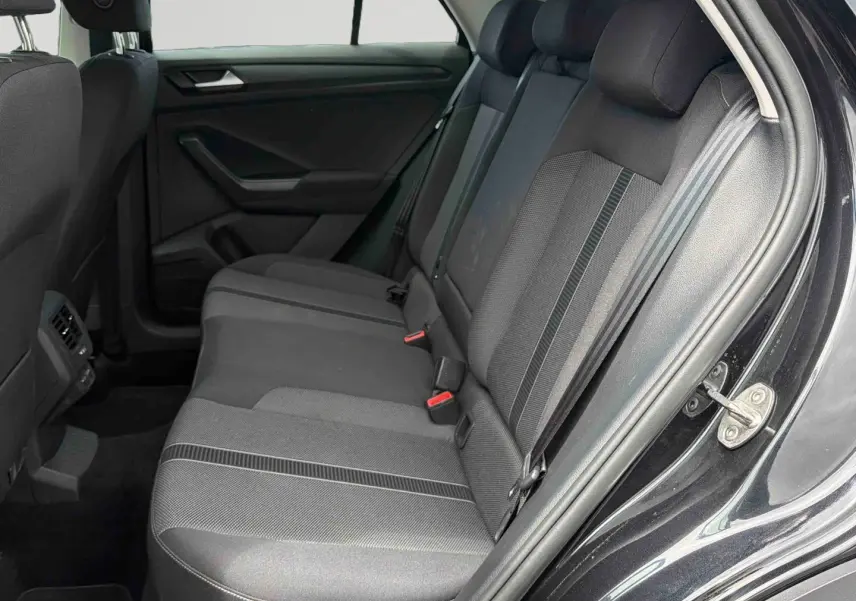 Vue intérieure côté droit sur la banquette arrière noire du Volkswagen T-Roc 2025 avec tissus et ceintures visibles.