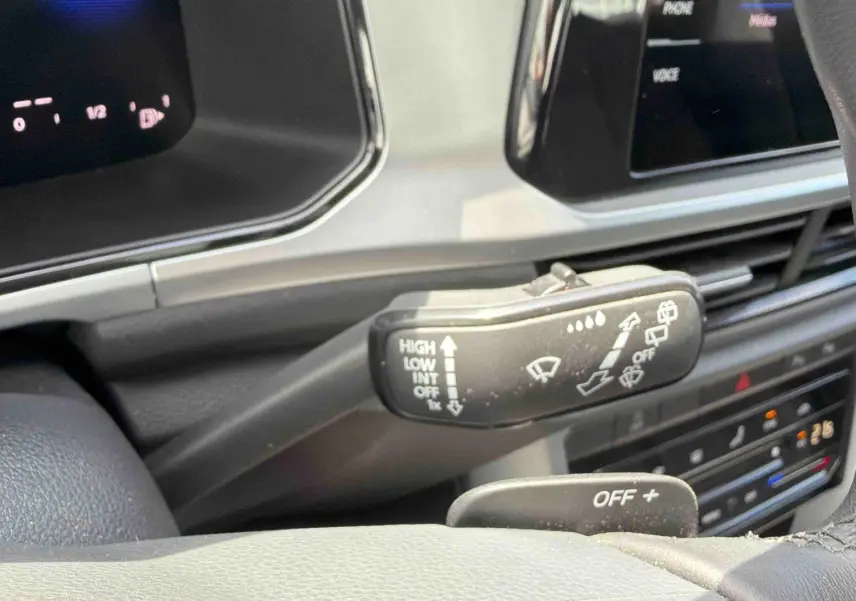 Gros plan sur la manette d’essuie-glace à gauche du volant dans l’habitacle du Volkswagen T-Roc noir 2025.
