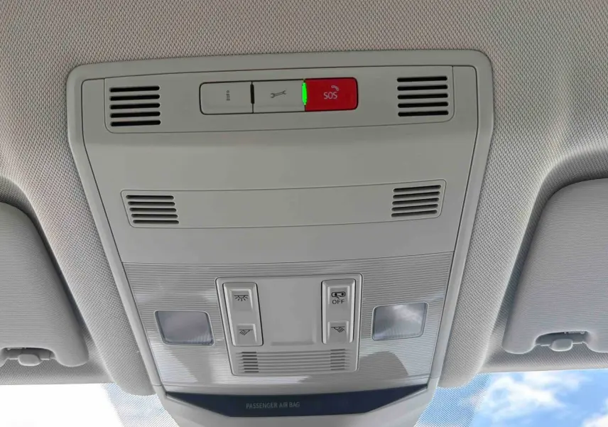 Vue intérieure du plafonnier gris clair avec boutons de commande et alerte SOS allumée dans un Volkswagen T-Roc noir.