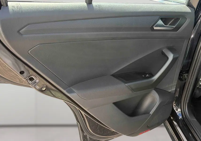 Vue rapprochée de la porte arrière gauche noire du Volkswagen T-Roc 2025, montrant la poignée et les commandes de fenêtre.