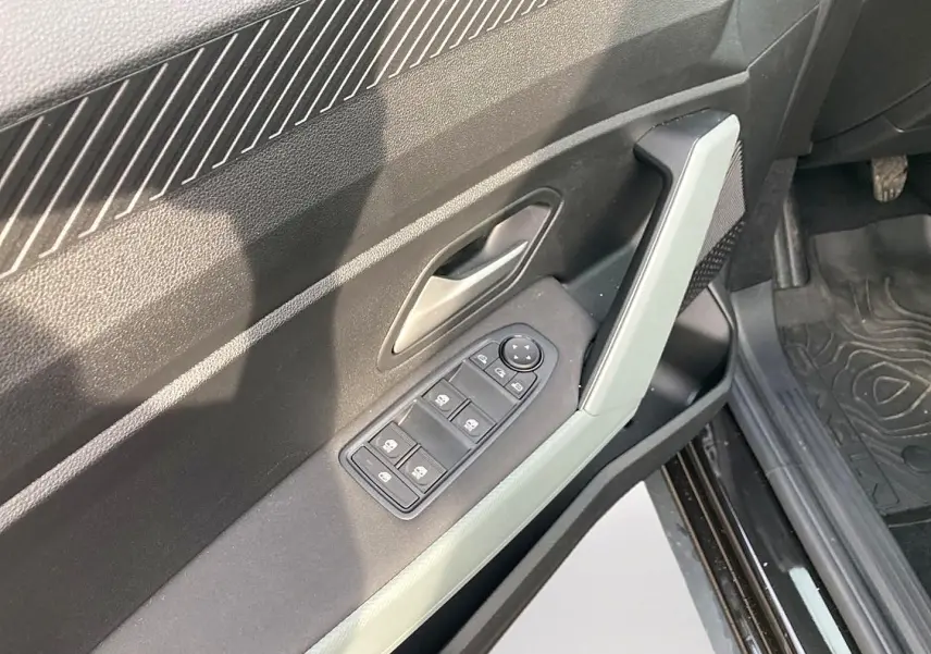 Détail de la porte avant gauche noire du Dacia Bigster 2025 avec commandes électriques des vitres et poignée intégrée.