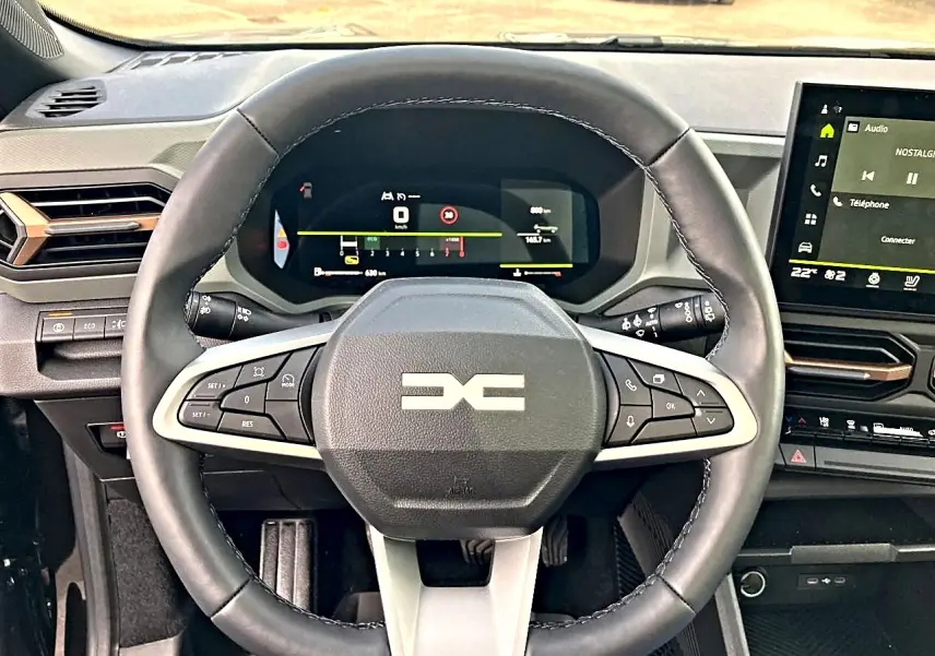Vue rapprochée du volant multifonction noir et du tableau de bord numérique du Dacia Bigster 2025.