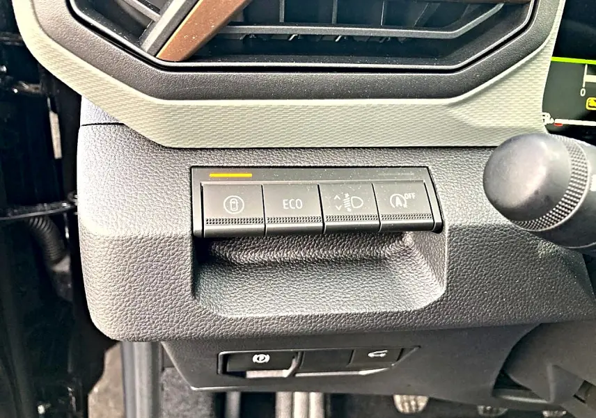 Gros plan sur les commandes de tableau de bord noir du Dacia Bigster 2025, avec bouton ECO et régulateur d’éclairage.