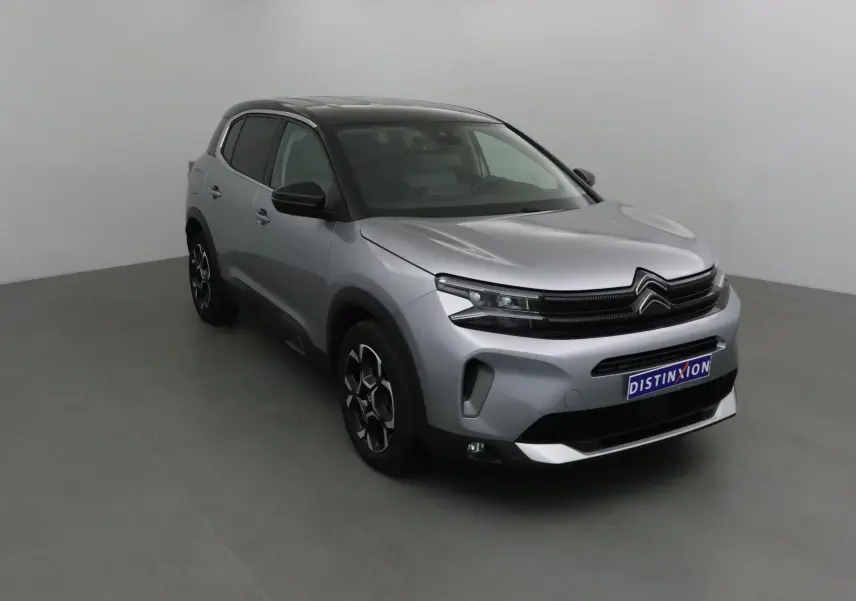 Citroën C5 Aircross 2024 gris Artense avec toit noir, vue 3/4 avant mettant en valeur ses optiques LED et jantes stylées.