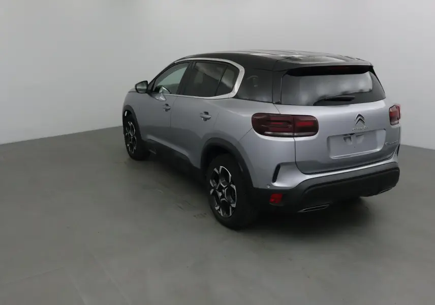 Citroën C5 Aircross 2024 gris Artense et noir, vue 3/4 arrière côté gauche dans un studio neutre.