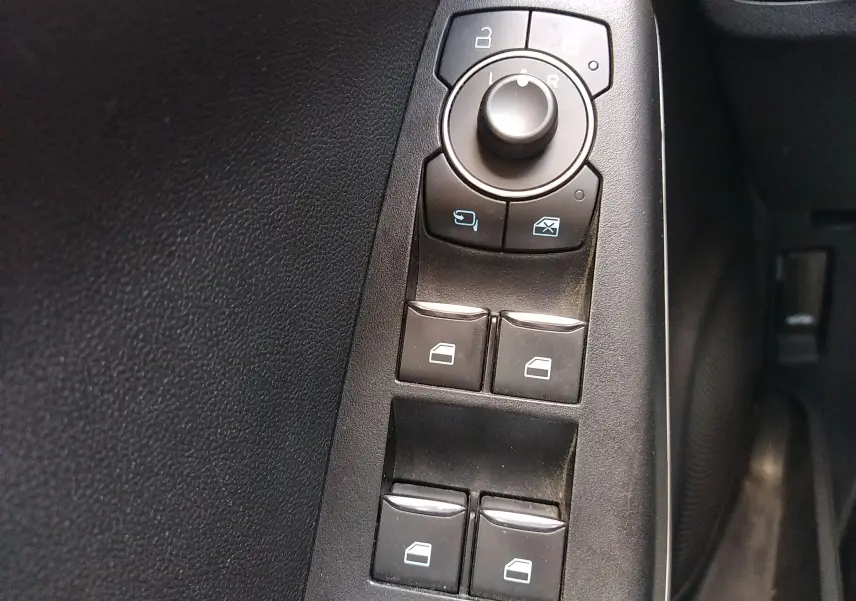 Panneau de commandes des vitres et rétroviseurs côté conducteur du Ford Puma blanc 2021, finition Titanium.