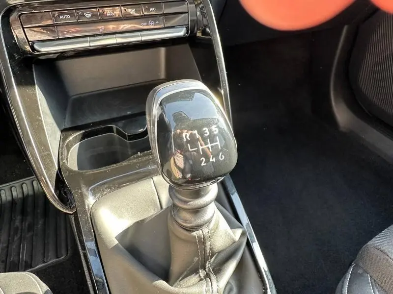 Le levier de vitesses manuel noir de la Citroën C3 1.2 Turbo 100ch MAX vu en gros plan depuis l'avant.