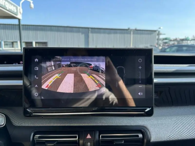 Écran tactile intérieur de la Citroën C3 2025 montrant la caméra de recul avec vue arrière sur un passage piéton.