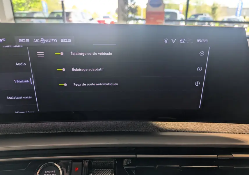 Écran tactile du tableau de bord du Peugeot 5008 Hybrid 145 GT affichant les réglages d’éclairage, vue intérieure frontale.