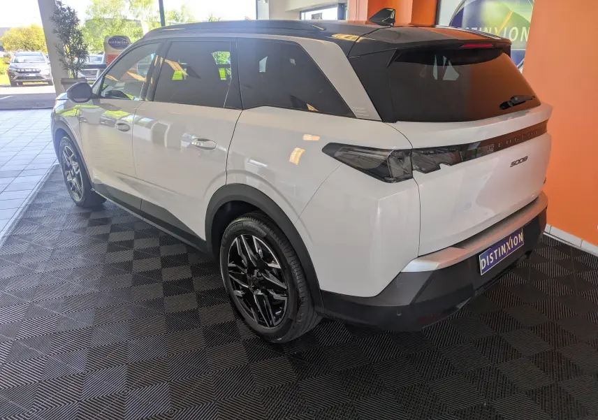 Peugeot 5008 Hybrid 145 GT blanc Okenite avec toit noir, vue 3/4 arrière droit, jantes alliage noires 19 pouces.