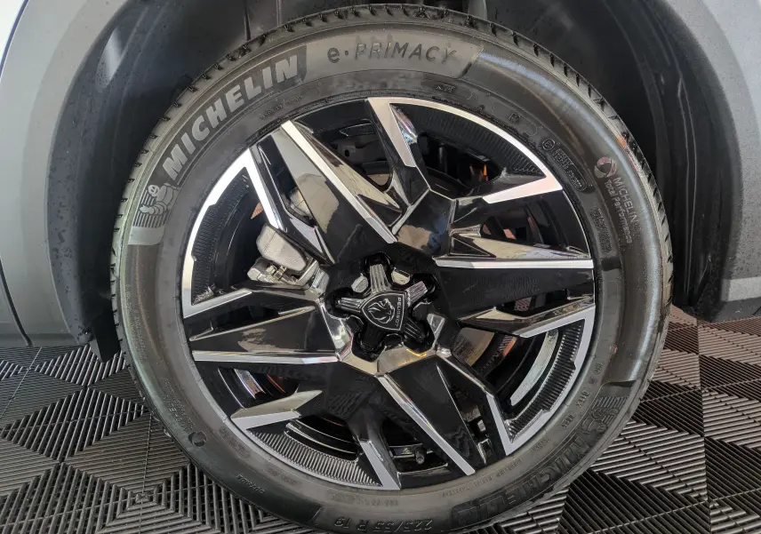 Gros plan sur la jante alliage 19’’ noire et polie du Peugeot 5008 Hybrid 145 e-DCS6 GT, pneu Michelin e-Primacy visible.
