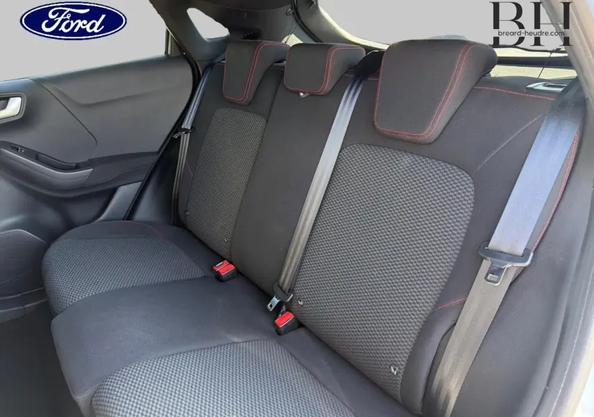 Vue intérieure du siège arrière droit de la Ford Puma 2023 avec tissu noir et surpiqûres rouges visibles.