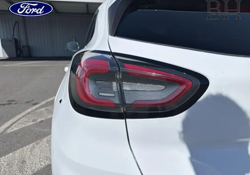 Gros plan sur le feu arrière gauche du Ford Puma blanc Glacier, avec vitres arrière surteintées visibles.