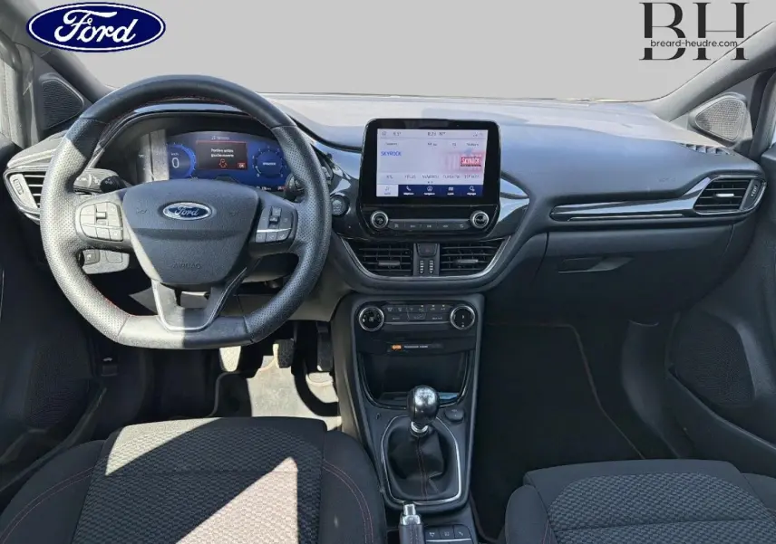 Vue intérieure avant du Ford Puma 2023 montrant le volant multifonction, écran tactile central et levier de vitesse manuel.