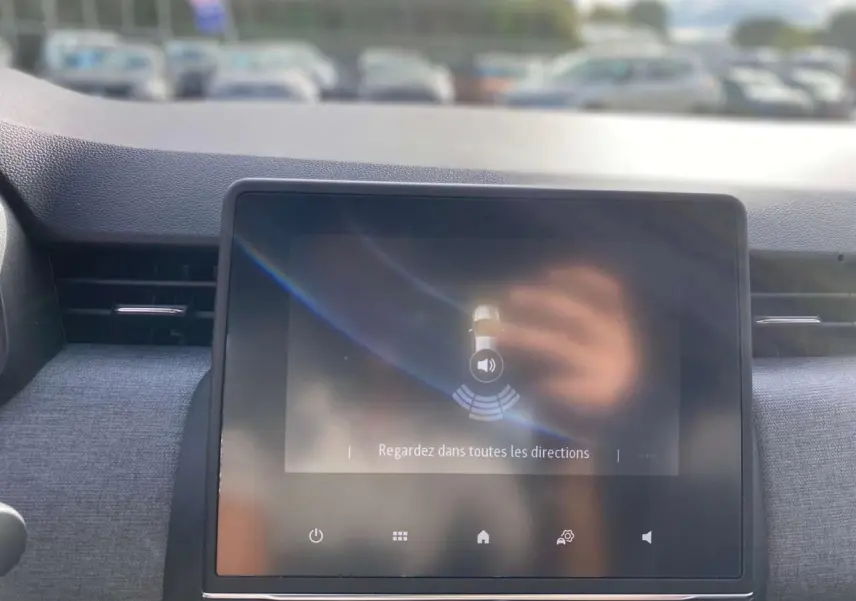 Écran tactile central de la Renault Clio 2025 affichant l'aide au stationnement arrière dans un intérieur gris.