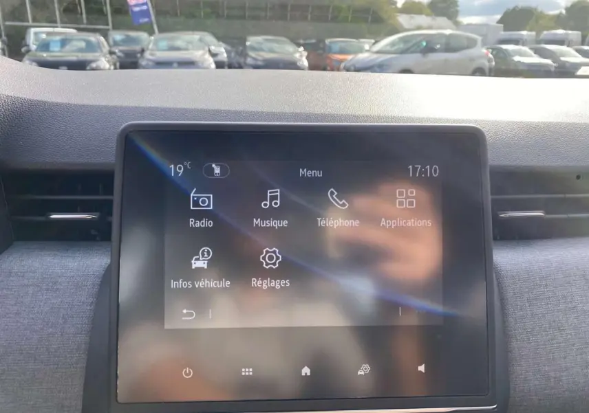 Écran tactile central de la Renault Clio noire étoilé 2025, affichant menu radio, musique et téléphone.