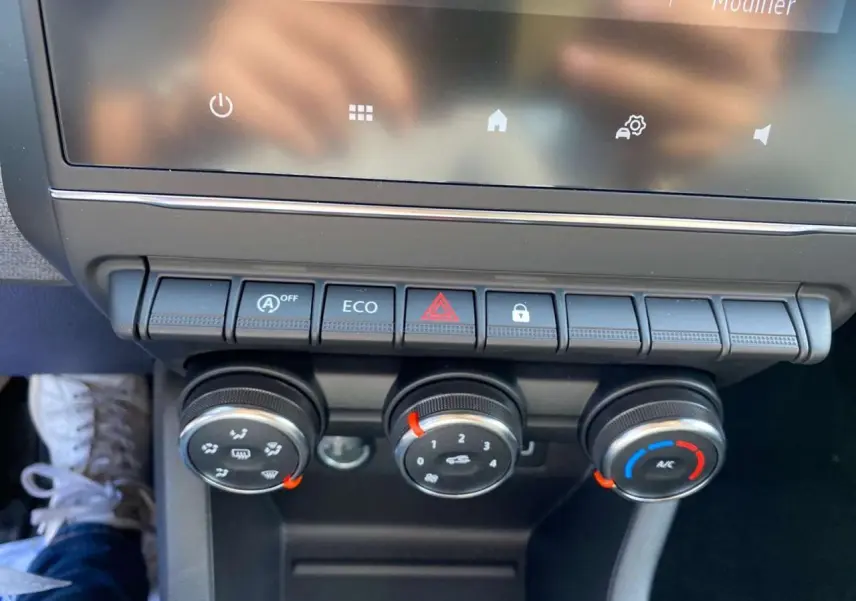 Gros plan sur la console centrale de la Renault Clio 2025 avec commandes de climatisation manuelle et boutons fonctionnels.