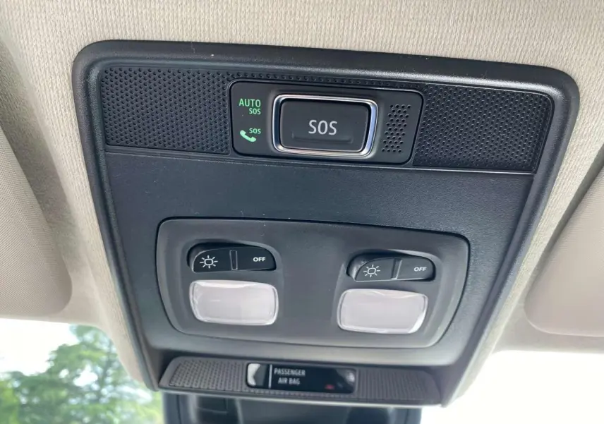 Boutons d'éclairage et alerte SOS en gros plan sur le plafond intérieur d'une Renault Clio noire étoile 2025.