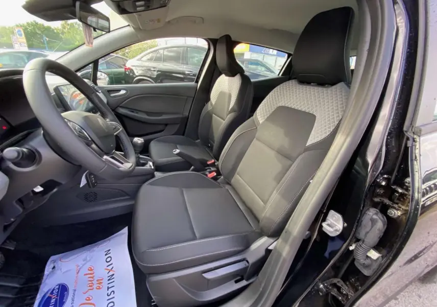 Vue intérieure côté conducteur de la Renault Clio 2025 noire étoile, montrant les sièges avant et le volant.
