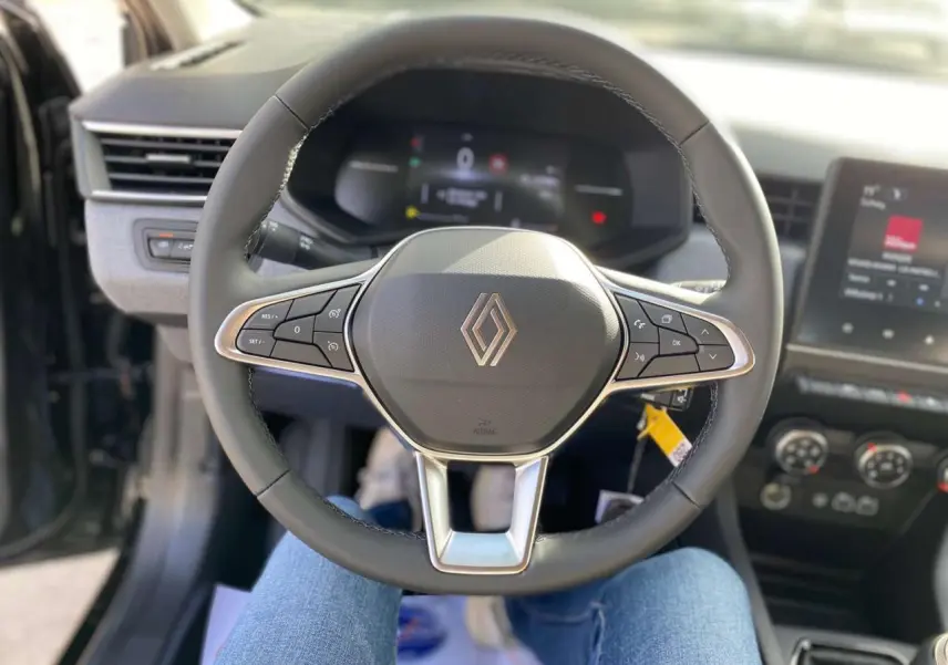 Vue centrée sur le volant cuir noir de la Renault Clio 2025 avec commandes intégrées et tableau de bord numérique.