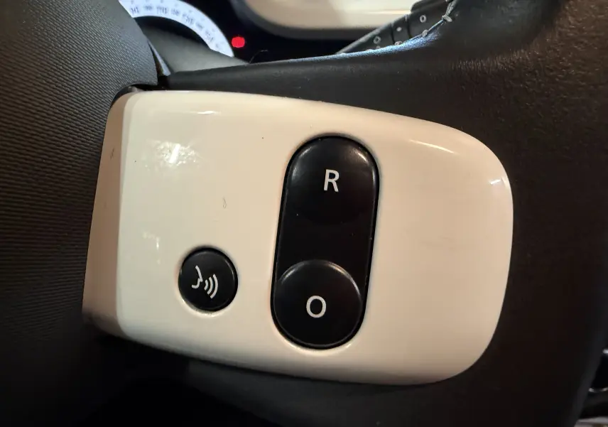 Gros plan sur les boutons de commande du volant blanc et noir dans l’habitacle de la Renault Twingo III gris 2018.