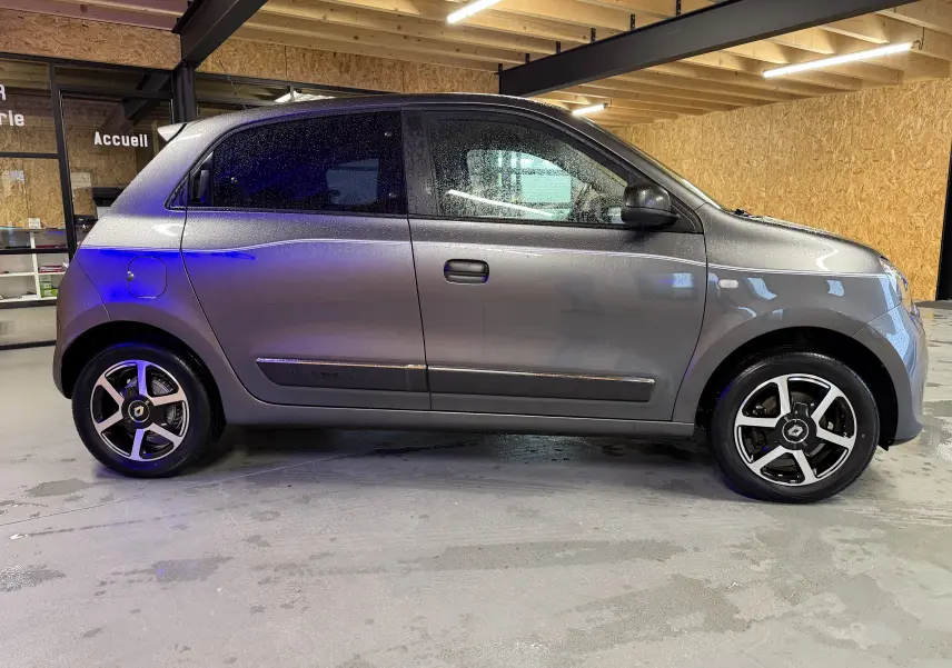 Profil droit d'une Renault Twingo III gris métallisé 2018, avec jantes alliage et rétroviseurs électriques visibles.