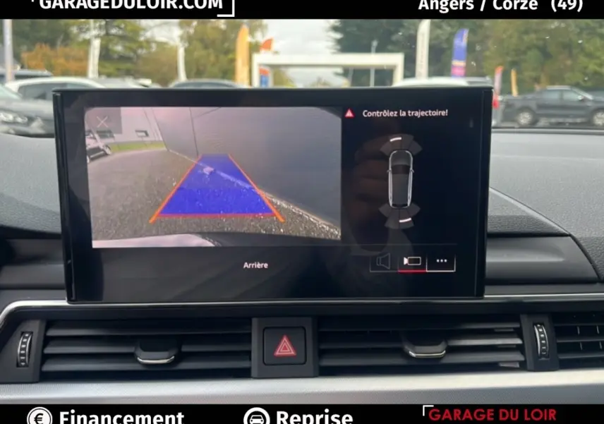 Écran tactile intérieur affichant la caméra de recul et l’aide au stationnement de l’Audi A4 noire, vue de face.