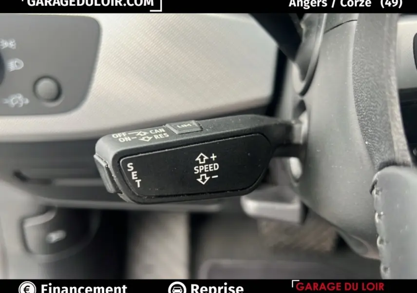 Gros plan sur la commande de régulateur de vitesse noire à gauche du volant d'une Audi A4 noire de 2020.