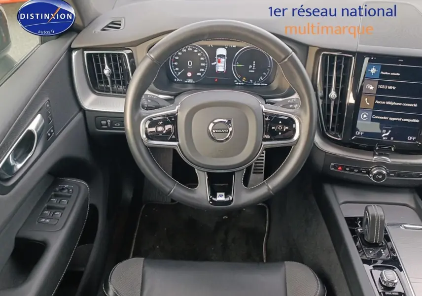 Vue intérieure frontale du volant cuir noir et tableau de bord numérique du Volvo XC60 blanc 2021.