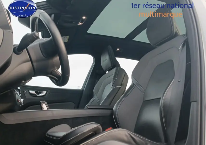 Vue intérieure côté conducteur du Volvo XC60 2.0 T8 blanc, mettant en valeur les sièges sport et le toit panoramique.