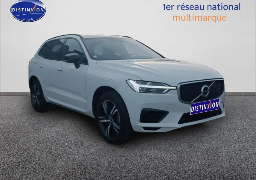 Volvo XC60 blanc en 3/4 avant droit, avec calandre noire et jantes alliage foncé visibles.