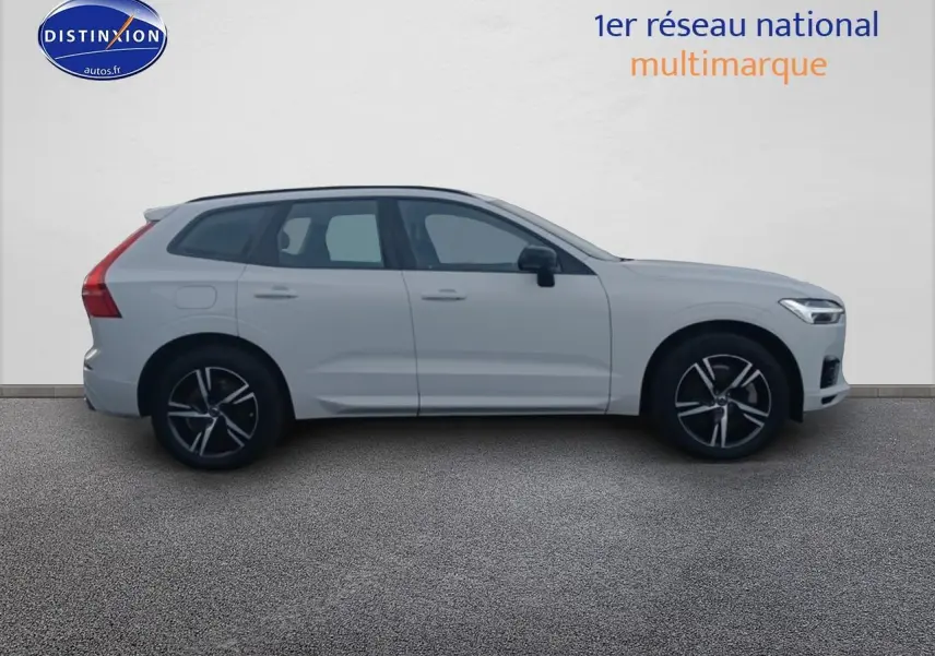 Profil côté gauche d'un Volvo XC60 blanc 2021 avec jantes alu noires et toit panoramique en verre.