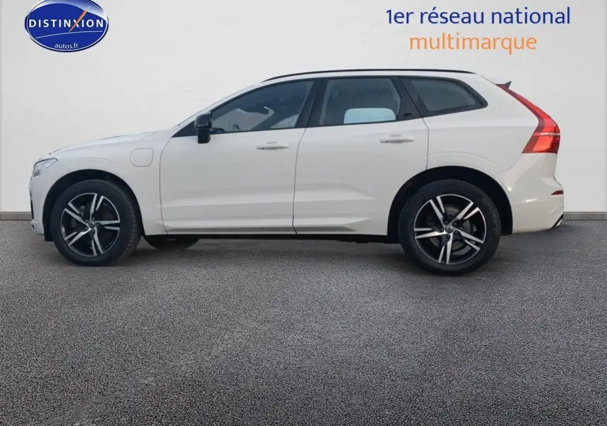 Profil droit d’un Volvo XC60 blanc 2021 avec jantes alliage noires et toit panoramique en verre visible.