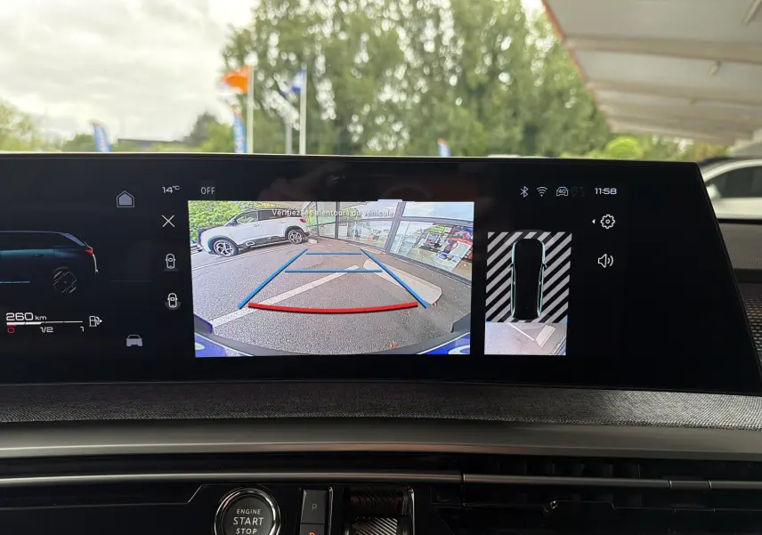 Vue arrière caméra de recul du Peugeot 5008 Hybrid blanc Okenite avec toit noir, affichée sur l'écran intérieur.