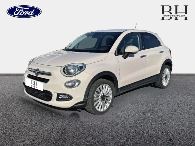 Vue 3/4 avant droite d'une FIAT 500X argentée avec jantes alu et boucliers couleur caisse sur fond neutre.
