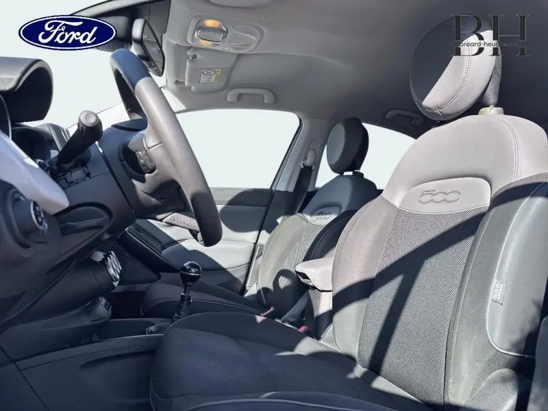 Vue intérieure côté conducteur de la Fiat 500X 2015, sièges tissu bi-color noir et gris avec logo 500 brodé.